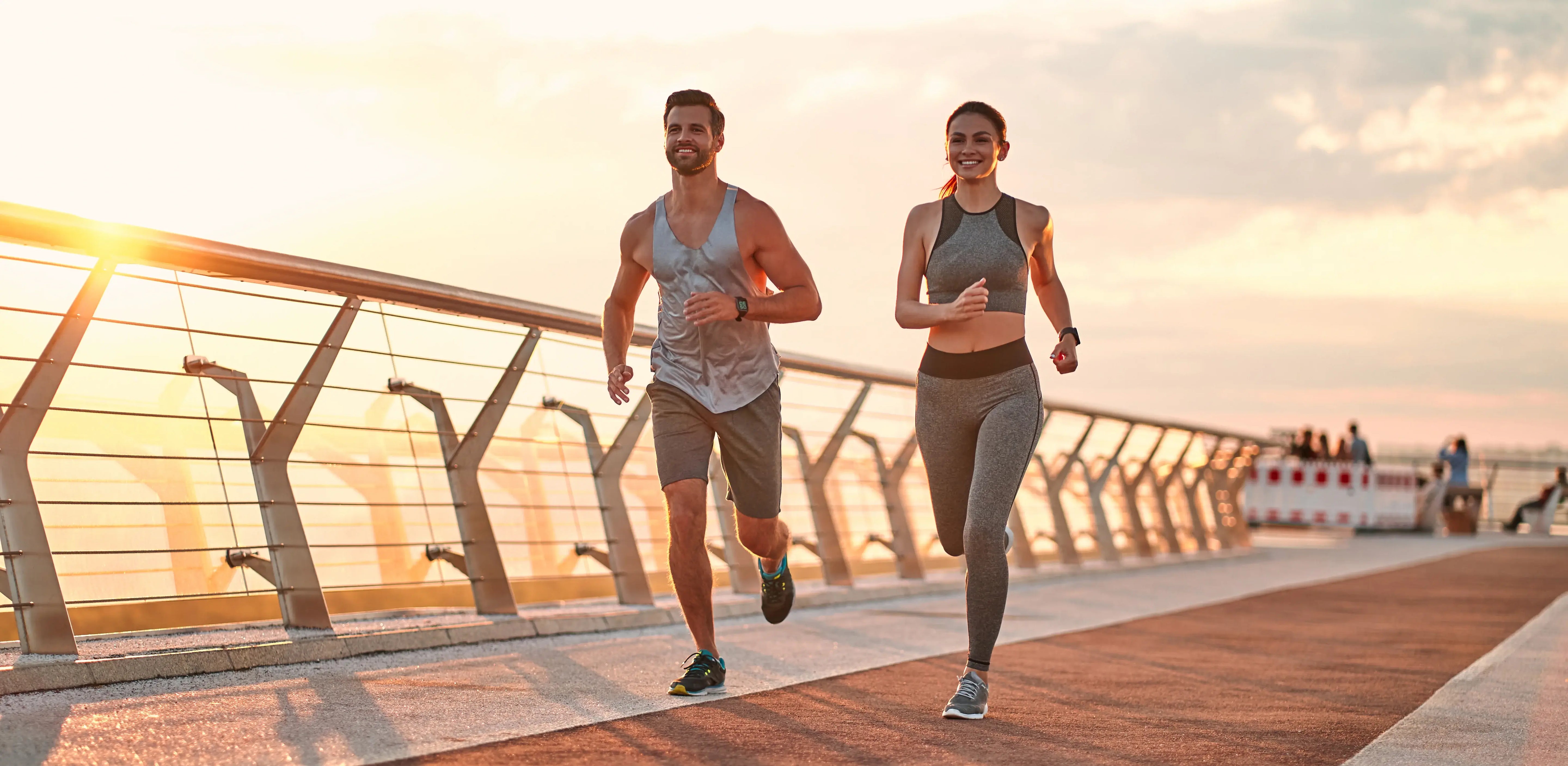 Two people running on a promenade with a scenic background